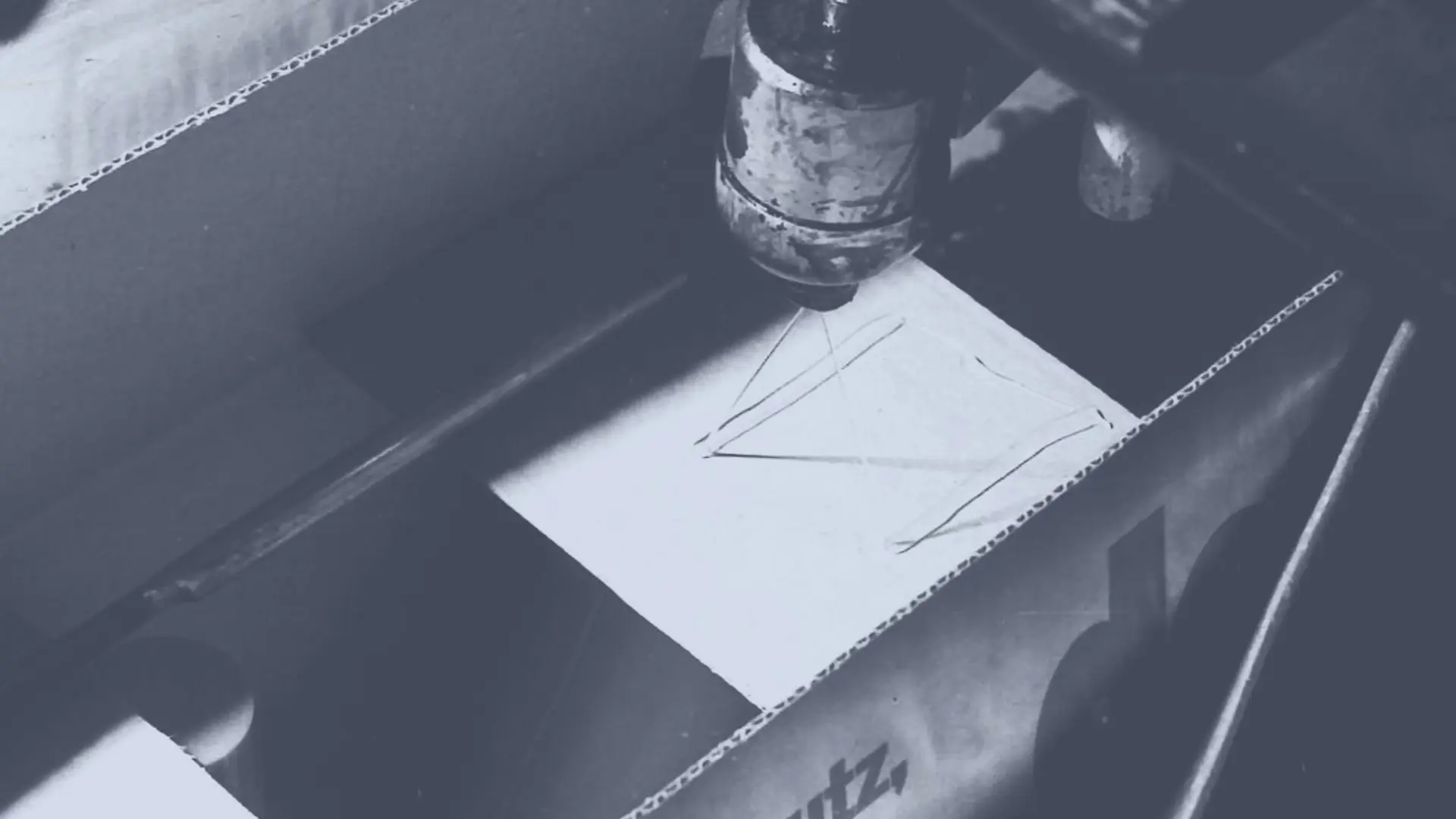 يتم تطبيق مادة اللصق الذائبة حرارياً Technomelt على صندوق من الكرتون بواسطة رأس رشّ لإغلاقه.