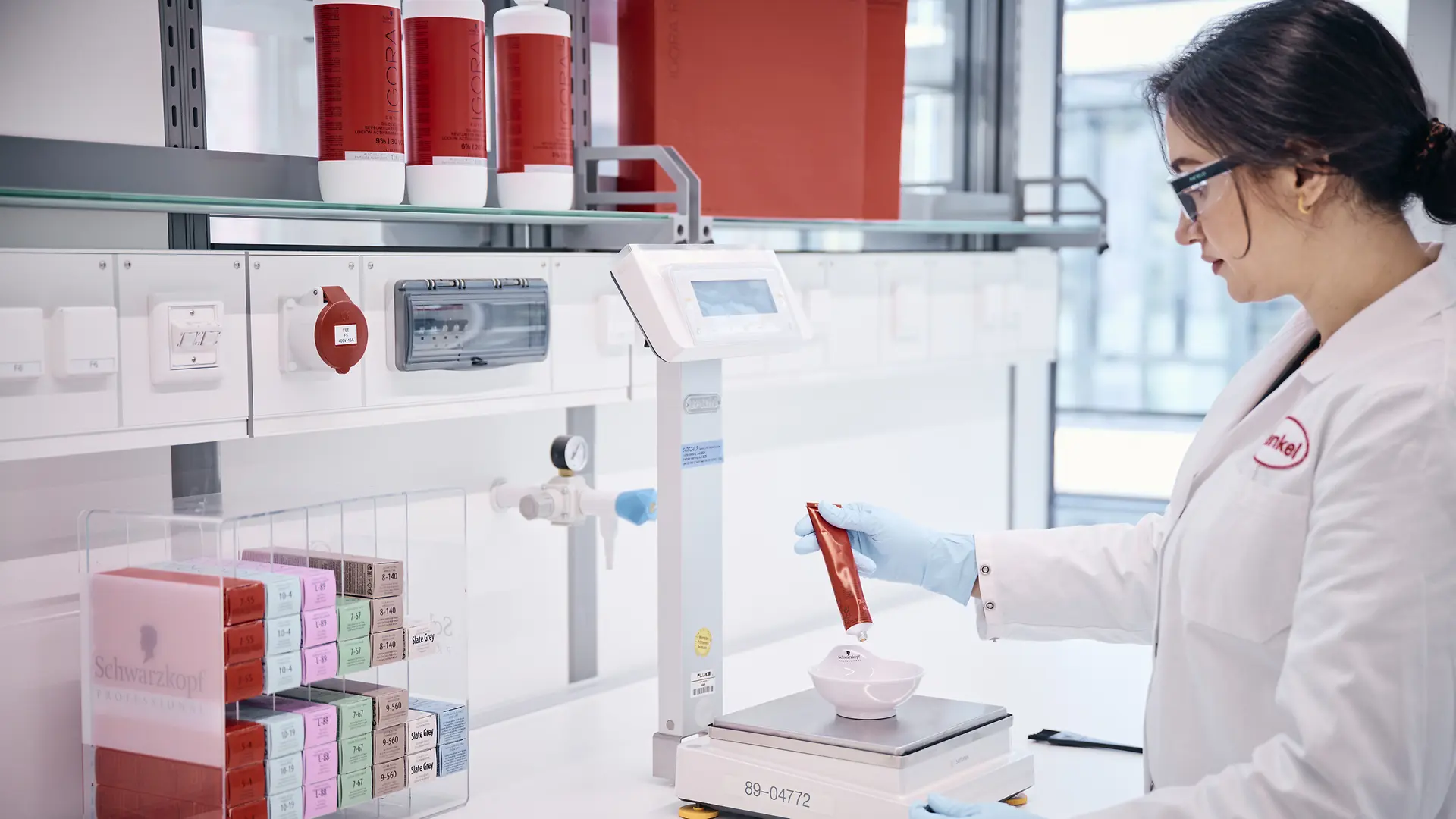 موظف مختبر يزن منتجات اختبارية.